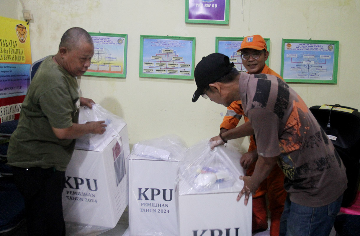 Ketua RW 08 Menteng Jaya dikawal angota kepolisian saat meriksa kotak suara logistik Pilkada 2024 di kantor Sekretariat RW 08, Kawasan Menteng Jaya, Jakarta Pusat, Selasa (26/11/2024).(BeritaNasional.com/Oke Atmaja)