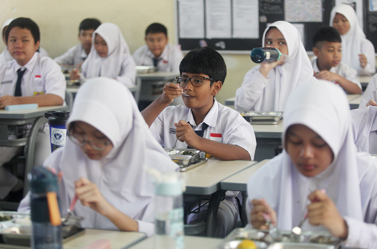 Siswa menyantap makanan bergizi gratis di SMP Barunawati Slipi, Jakarta, Senin (6/1/2025).(BeritaNasional.com/Oke Atmaja)