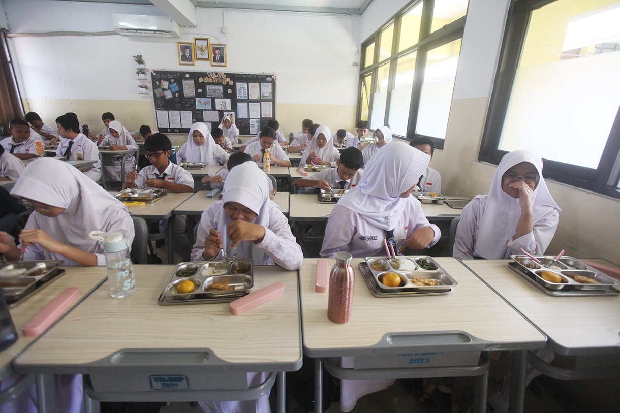 Siswa menyantap makanan bergizi gratis di SMP Barunawati Slipi, Jakarta, Senin (6/1/2025).(BeritaNasional.com/Oke Atmaja)