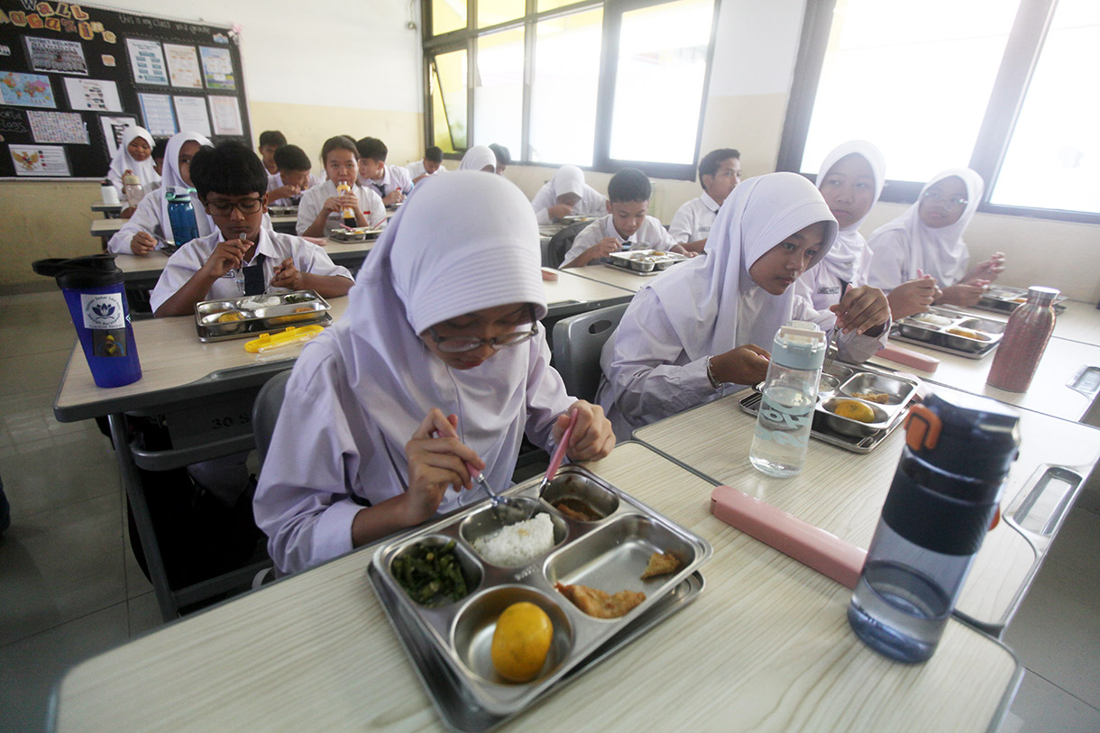 Siswa menyantap makanan bergizi gratis di SMP Barunawati Slipi, Jakarta, Senin (6/1/2025).(BeritaNasional.com/Oke Atmaja)