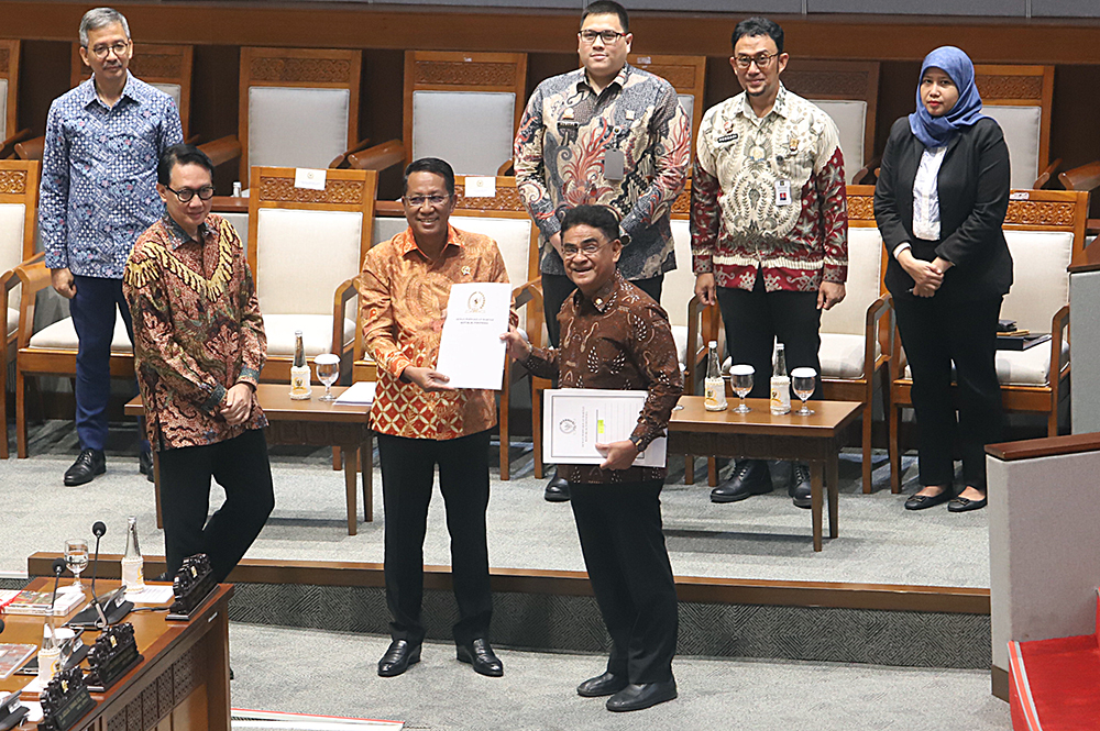 Menteri Hukum Supratman Andi Agtas (kiri) berkas pendapat akhir  saat Rapat Paripurna Ke-6 DPR Masa Persidangan I Tahun 2025-2026. (BeritaNasional/Elvis Sendouw)