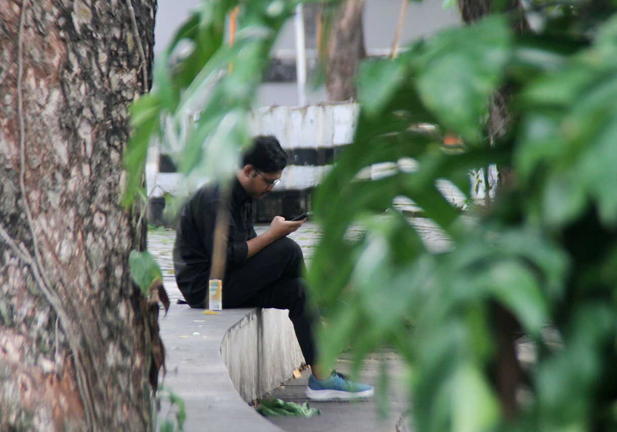 Warga sedang memainkan Handphone di Taman Suropati, Jakarta, Senin (18/11/2024).  (BeritaNasional.com/Oke Atmaja)