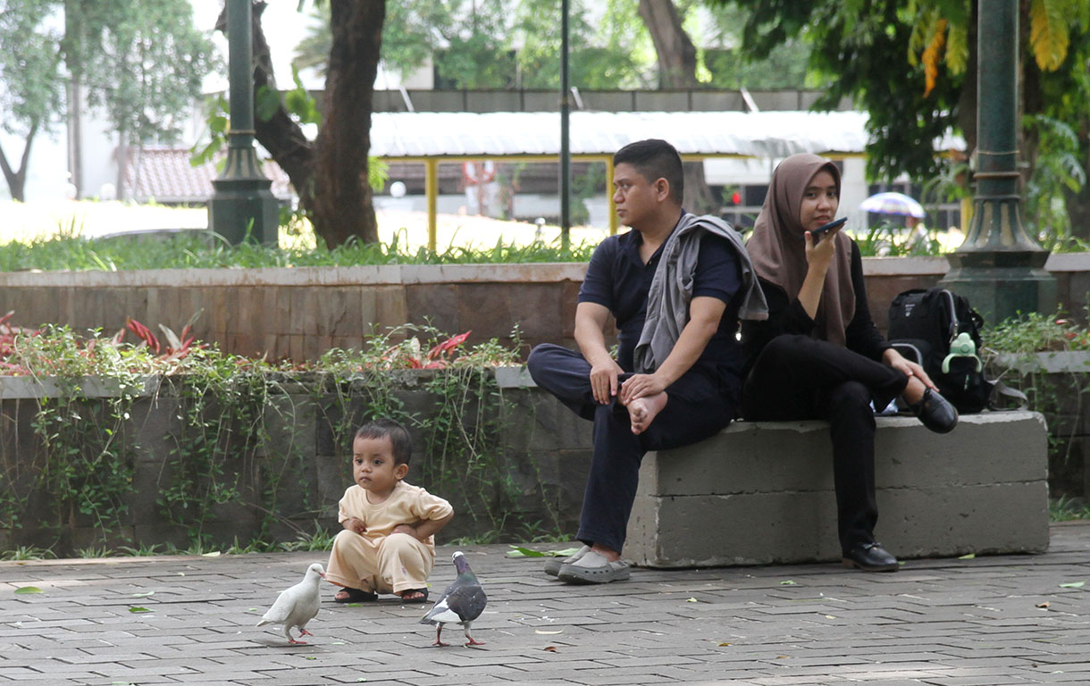 Warga sedang memainkan Handphone di Taman Suropati, Jakarta, Senin (18/11/2024).  (BeritaNasional.com/Oke Atmaja)