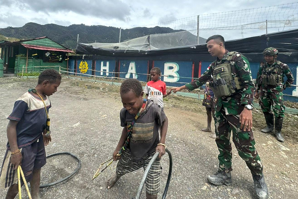 Prajurit Satgas Yonif 509 Kostrad bermai bersama anak-anak Papua. (BeritaNasional/HO/Elvis Sendouw)