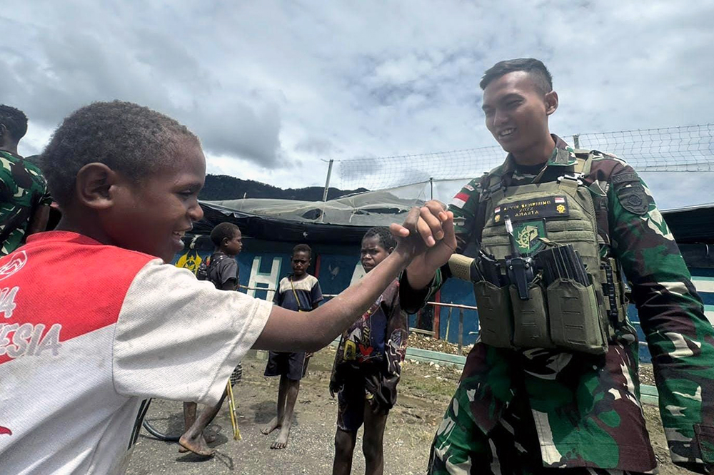 Prajurit Satgas Yonif 509 Kostrad bermai bersama anak-anak Papua. (BeritaNasional/HO/Elvis Sendouw)