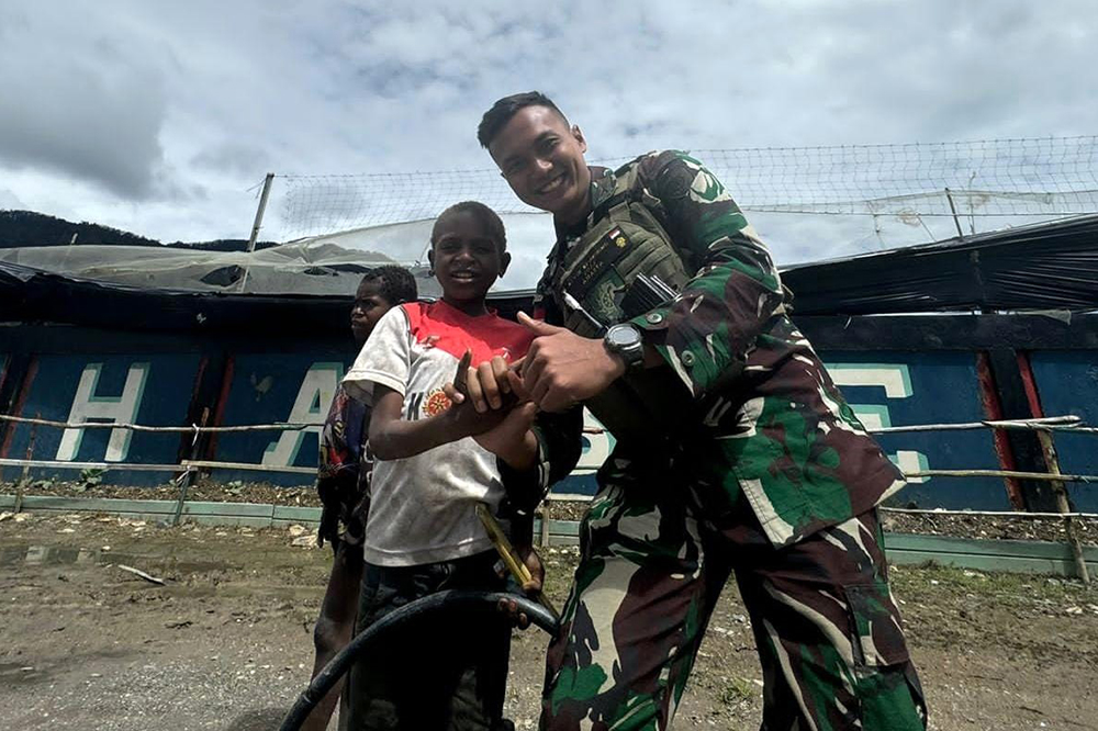 Prajurit Satgas Yonif 509 Kostrad bermai bersama anak-anak Papua. (BeritaNasional/HO/Elvis Sendouw)