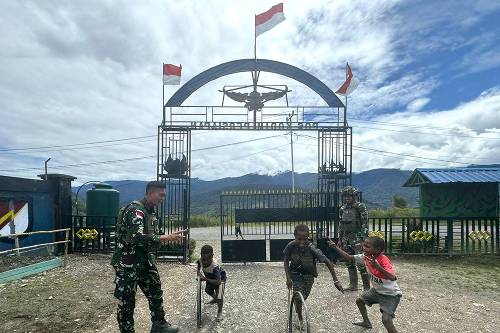 Prajurit Satgas Yonif 509 Kostrad bermai bersama anak-anak Papua. (BeritaNasional/HO/Elvis Sendouw)