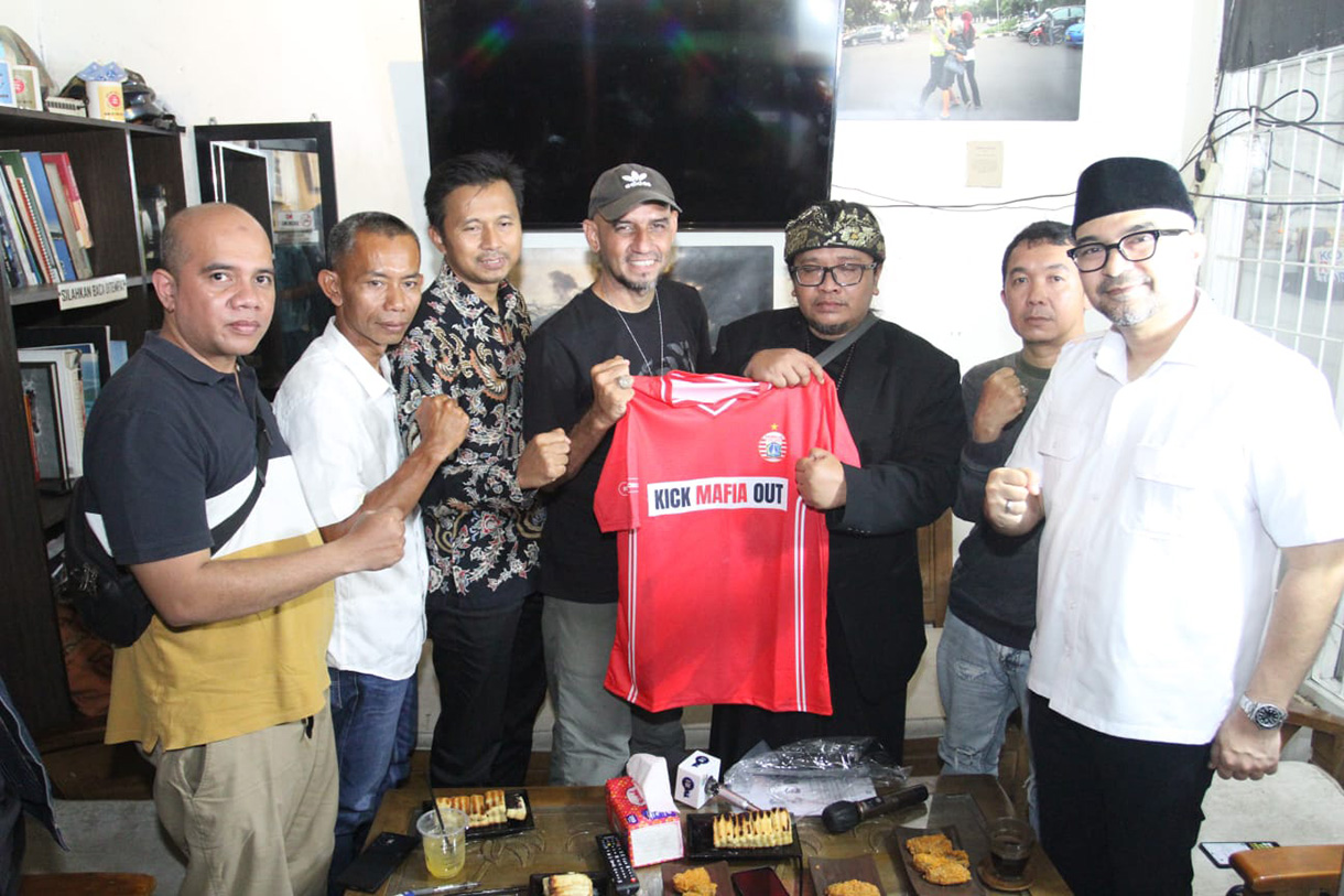 CEO Sinergi ADV Nusantara Prama Tirta (ketiga Kiri) memberikan baju kepada Seporter The Jakmania Garis Keras Bang Irfan (keempat Kanan) yang disaksikan oleh Ikatan Pengusaha Konveksi Berkarya (IPKB), Asosiasi Pertekstilan Indonesia (API), Asosiasi Produsen Serat & Benang Filamen Indonesia (APSyFI), Aliansi Industri Kecil Menengah Indonesia (AIKMI) di Kedai Coffe Halaman, Jakarta, Jumat (28/11/2025).  (Beritanasional.com/Oke Atmaja)