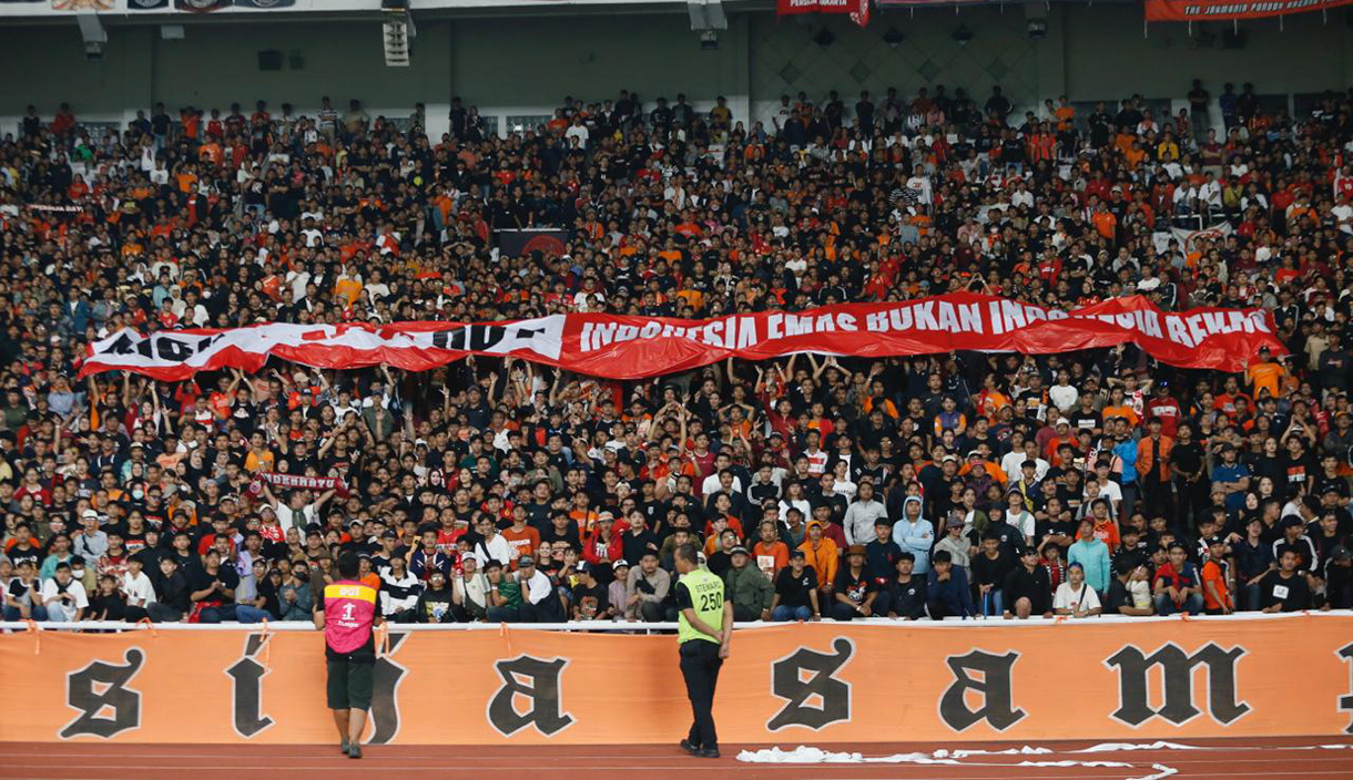 CEO Sinergi ADV Nusantara Prama Tirta (ketiga Kiri) memberikan baju kepada Seporter The Jakmania Garis Keras Bang Irfan (keempat Kanan) yang disaksikan oleh Ikatan Pengusaha Konveksi Berkarya (IPKB), Asosiasi Pertekstilan Indonesia (API), Asosiasi Produsen Serat & Benang Filamen Indonesia (APSyFI), Aliansi Industri Kecil Menengah Indonesia (AIKMI) di Kedai Coffe Halaman, Jakarta, Jumat (28/11/2025).  (Beritanasional.com/Oke Atmaja)
