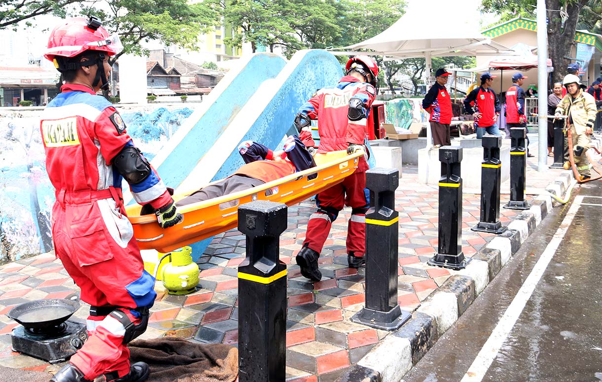Petugas mengarahkan seorang warga yang menggunakan alat pemadam api ringan (APAR) saat simulasi penanggulangan kebakaran di Perkampungan Menteng Tenggulun, Jakarta, Kamis (9/10/2025)  (Beritanasional.com/Oke Atmaja)