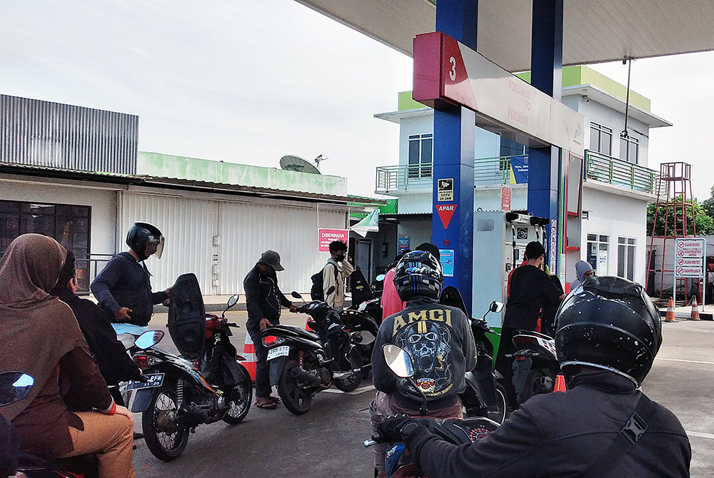 Pengendara motor saat antre mengisi bahan bakar minyak di SPBU. (BeritaNasional/Elvis Sendouw)