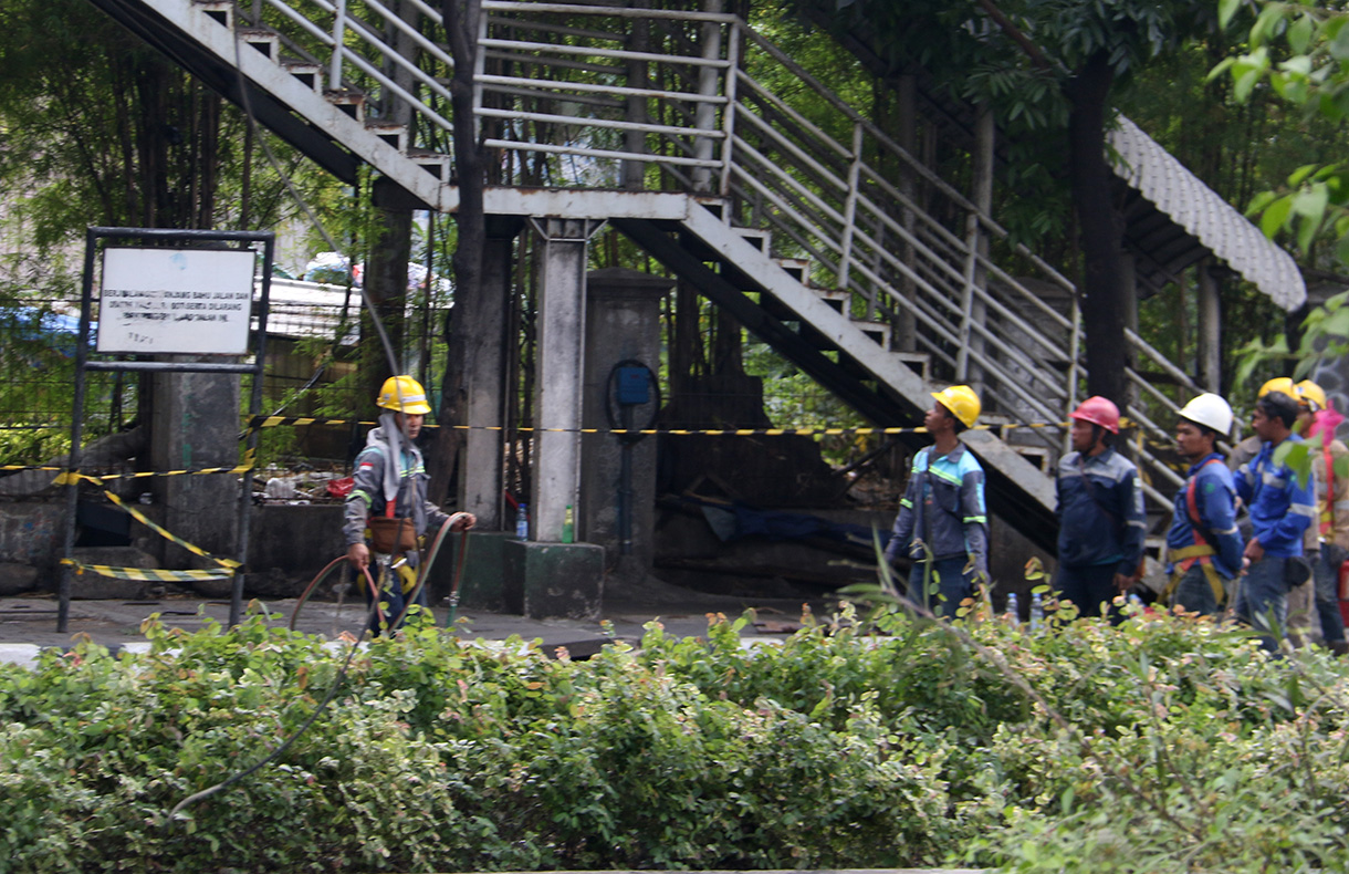 Petugas melakukan proses evakuasi truk bermuatan alat berat yang menabrak jembatan penyeberangan orang (JPO) di Jalan Kapten Tendean, Jakarta, Selasa (14/7/2026).  (Beritanasional.com/Oke Atmaja)