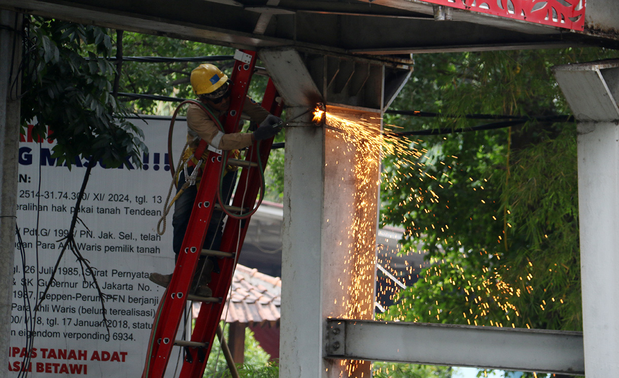 Petugas melakukan proses evakuasi truk bermuatan alat berat yang menabrak jembatan penyeberangan orang (JPO) di Jalan Kapten Tendean, Jakarta, Selasa (14/7/2026).  (Beritanasional.com/Oke Atmaja)