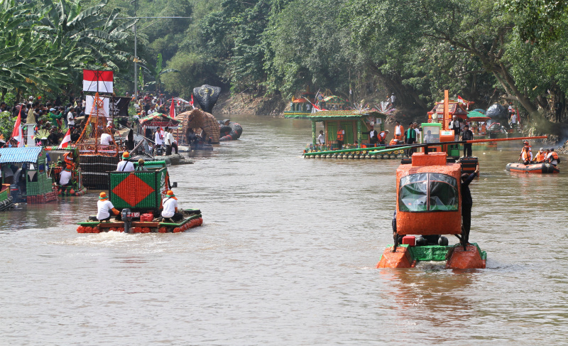 Peserta beratraksi di atas perahu unik berbahan limbah plastik saat parade Festival Cinta Lingkungan di Kali Ciliwung, Cikoko, Jakarta Selatan, Minggu (28/9/2025). (Berita nasional.com/Oke Atmaja)