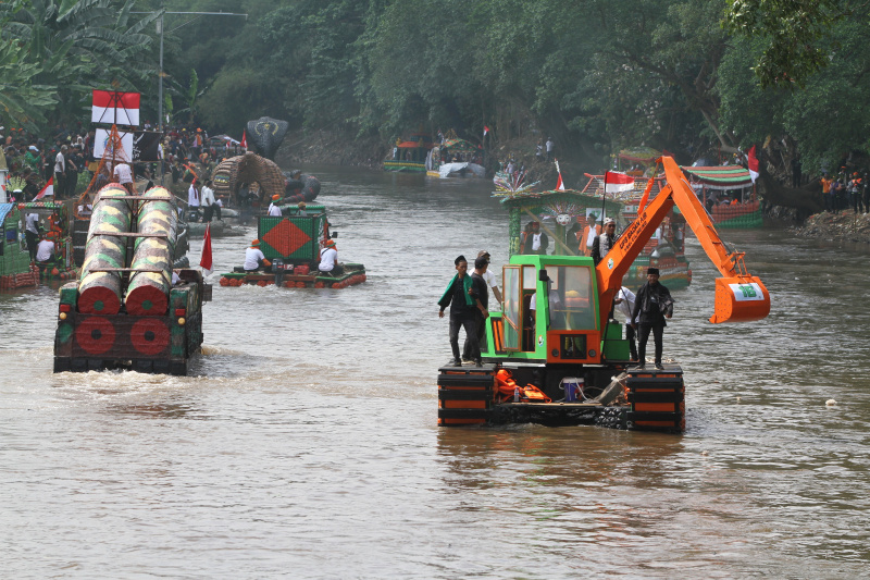 Peserta beratraksi di atas perahu unik berbahan limbah plastik saat parade Festival Cinta Lingkungan di Kali Ciliwung, Cikoko, Jakarta Selatan, Minggu (28/9/2025). (Berita nasional.com/Oke Atmaja)