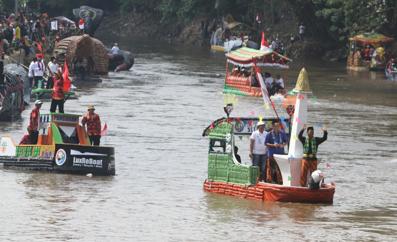 Peserta beratraksi di atas perahu unik berbahan limbah plastik saat parade Festival Cinta Lingkungan di Kali Ciliwung, Cikoko, Jakarta Selatan, Minggu (28/9/2025). (Berita nasional.com/Oke Atmaja)