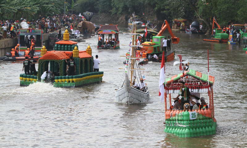 Peserta beratraksi di atas perahu unik berbahan limbah plastik saat parade Festival Cinta Lingkungan di Kali Ciliwung, Cikoko, Jakarta Selatan, Minggu (28/9/2025). (Berita nasional.com/Oke Atmaja)