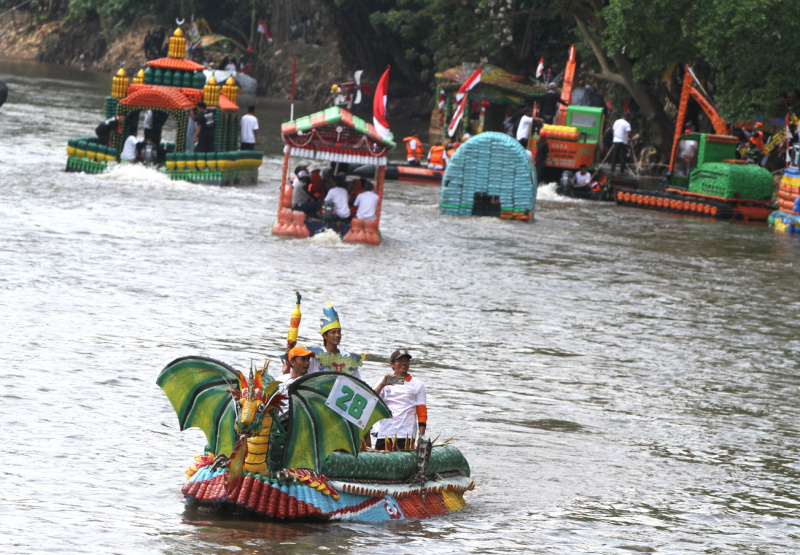 Peserta beratraksi di atas perahu unik berbahan limbah plastik saat parade Festival Cinta Lingkungan di Kali Ciliwung, Cikoko, Jakarta Selatan, Minggu (28/9/2025). (Berita nasional.com/Oke Atmaja)