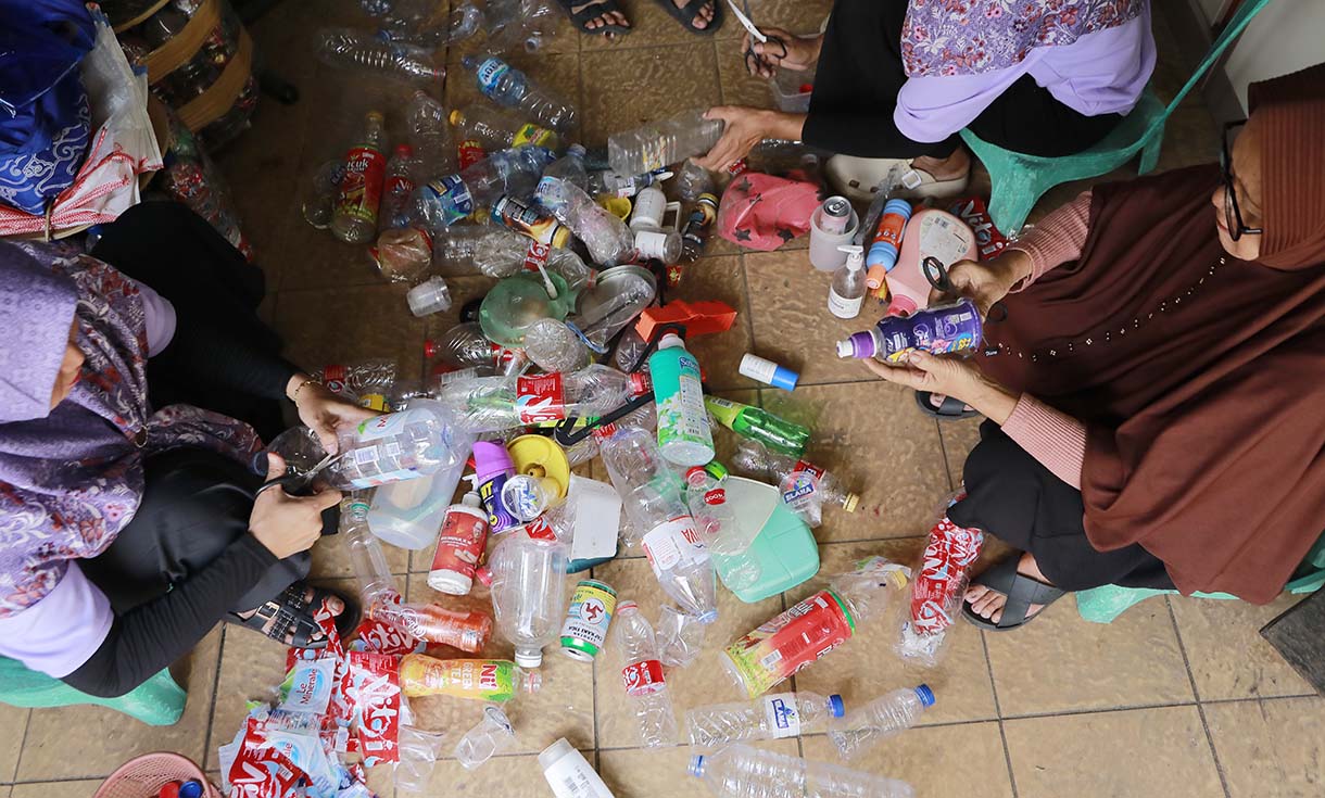 Warga melakukan proses sortir sampah botol plastik untuk didaur ulang di Bank Sampah Persatuan, Jalan Persatuan RW 08, Pondok Kelapa, Duren Sawit, Jakarta, Selasa (9/6/2026). (Beritanasional.com/Oke Atmaja)