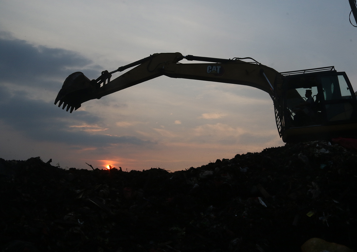 Alat berat diterjunkan mengangkut 'gunungan' sampah di Pasar Induk Kramat Jati, Jakarta, Selasa (7/4/2026).  (Beritanasional.com/Oke Atmaja)