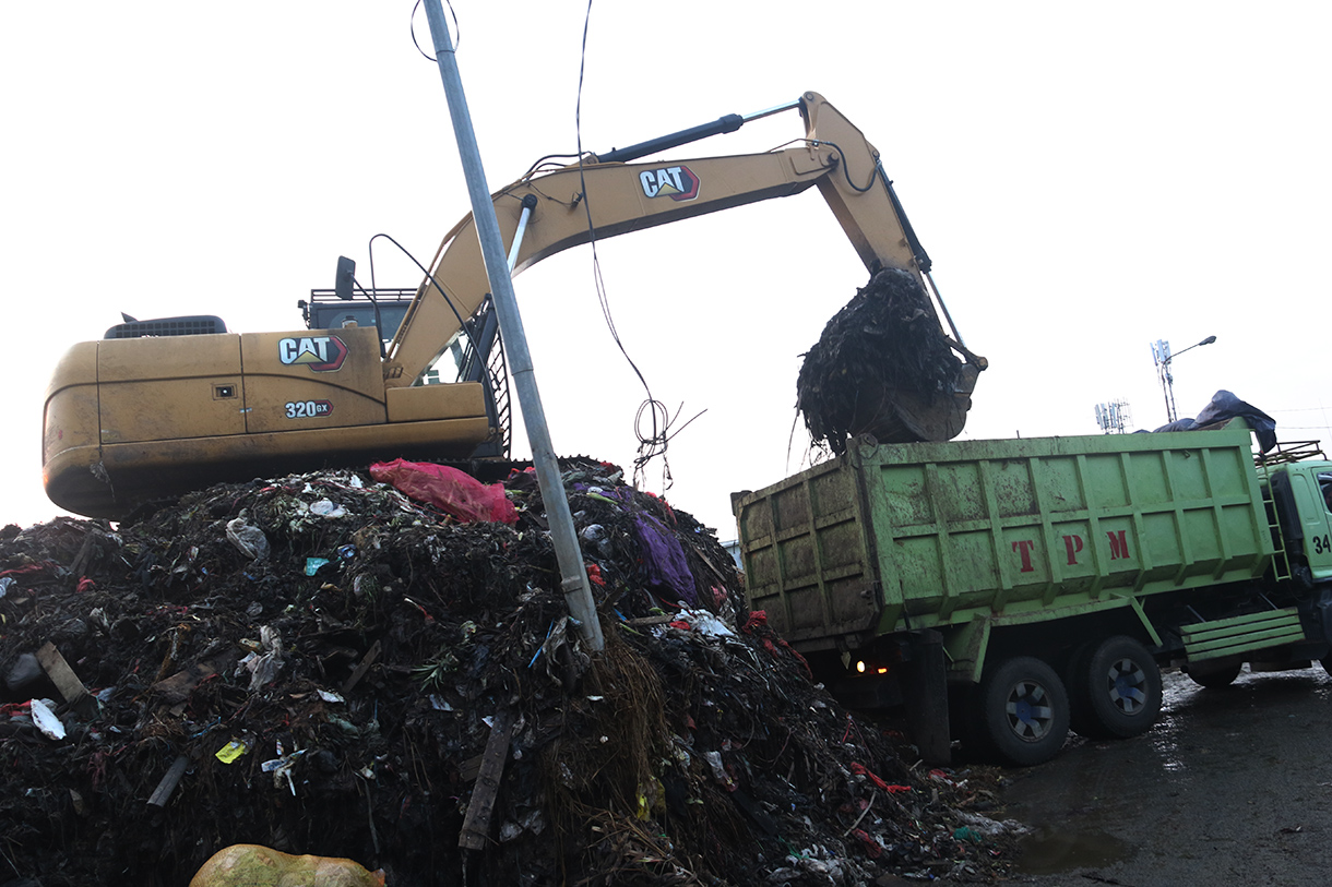 Alat berat diterjunkan mengangkut 'gunungan' sampah di Pasar Induk Kramat Jati, Jakarta, Selasa (7/4/2026).  (Beritanasional.com/Oke Atmaja)