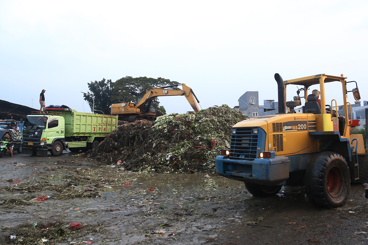 Alat berat diterjunkan mengangkut 'gunungan' sampah di Pasar Induk Kramat Jati, Jakarta, Selasa (7/4/2026).  (Beritanasional.com/Oke Atmaja)