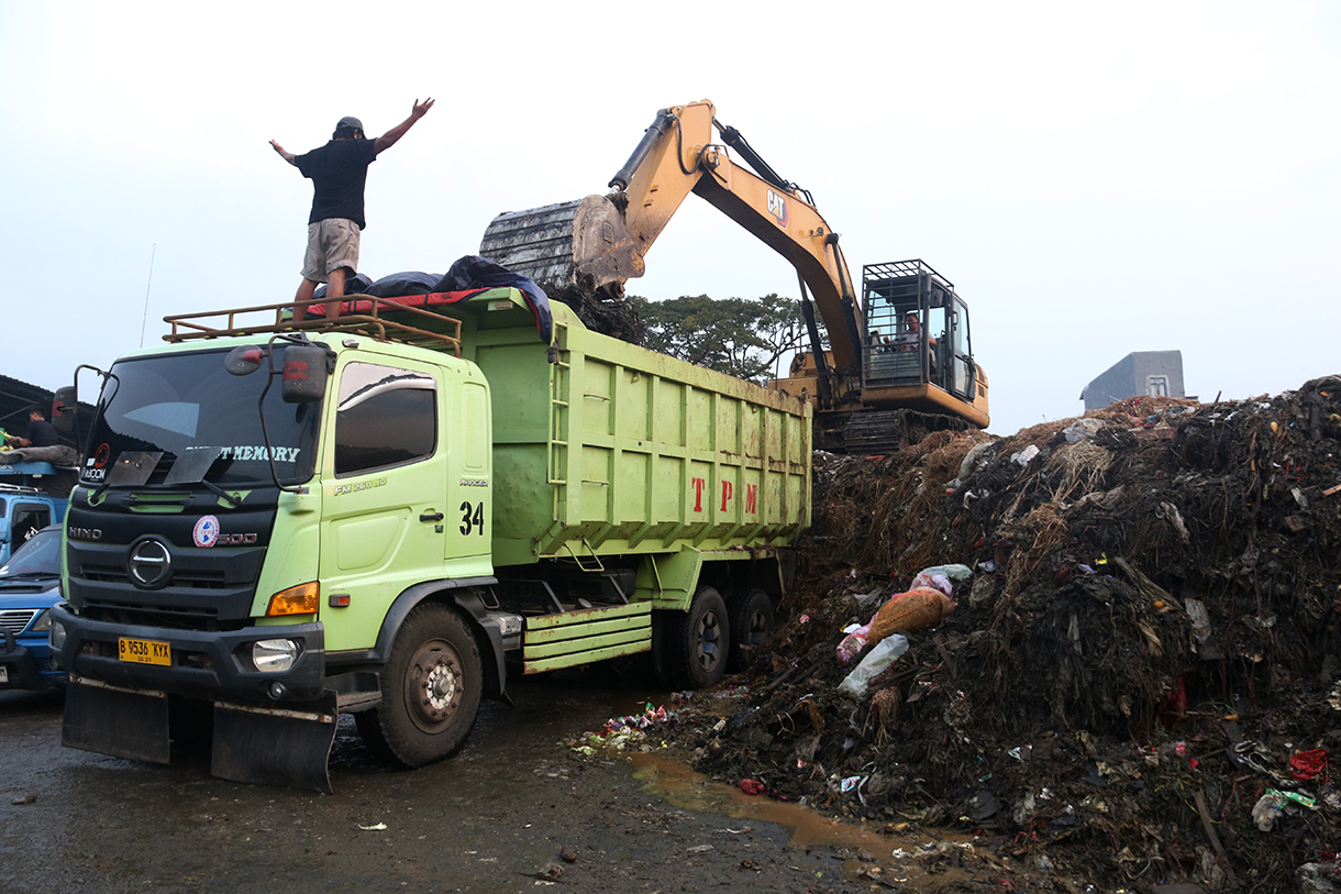 Alat berat diterjunkan mengangkut 'gunungan' sampah di Pasar Induk Kramat Jati, Jakarta, Selasa (7/4/2026).  (Beritanasional.com/Oke Atmaja)
