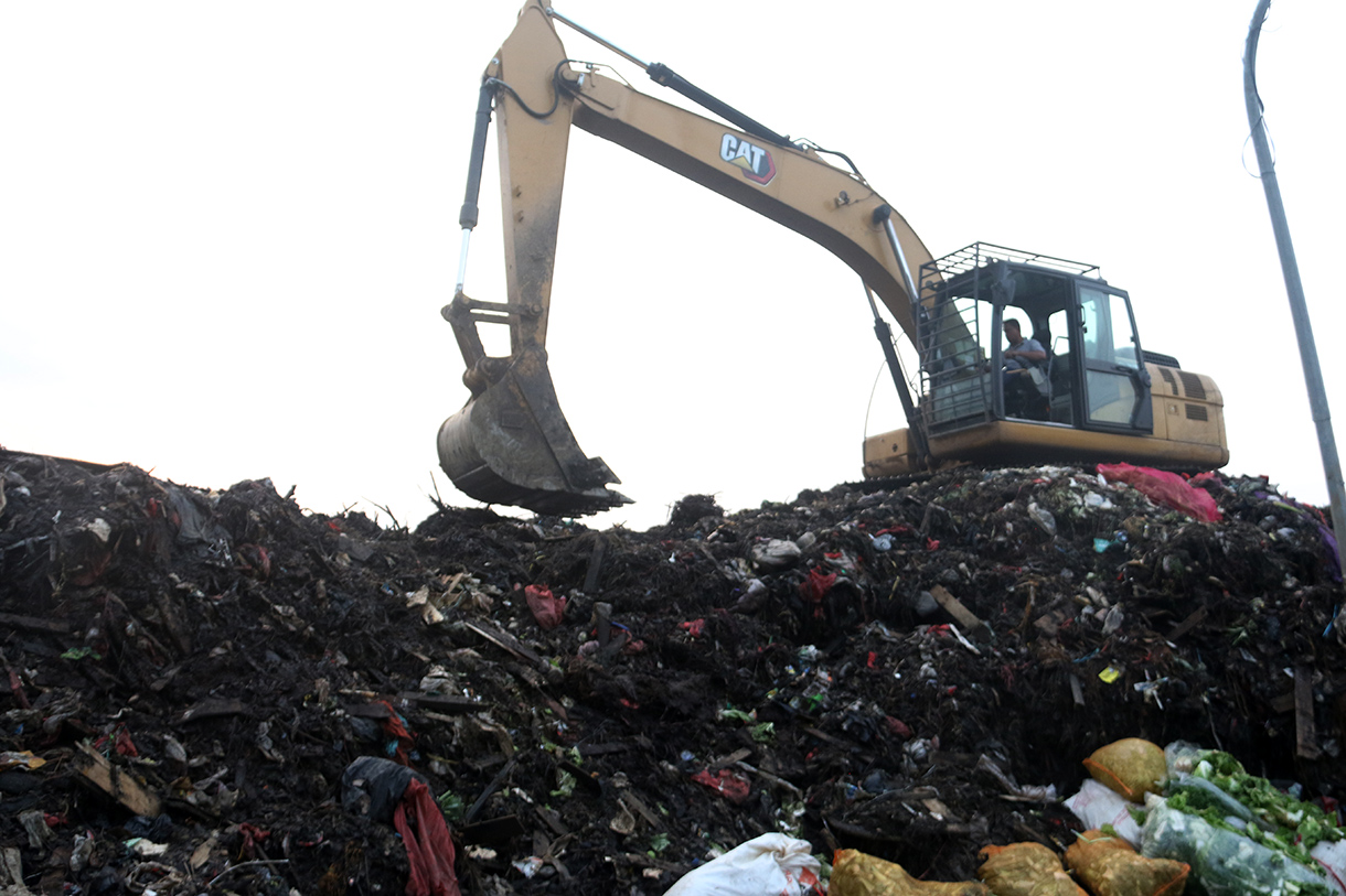 Alat berat diterjunkan mengangkut 'gunungan' sampah di Pasar Induk Kramat Jati, Jakarta, Selasa (7/4/2026).  (Beritanasional.com/Oke Atmaja)