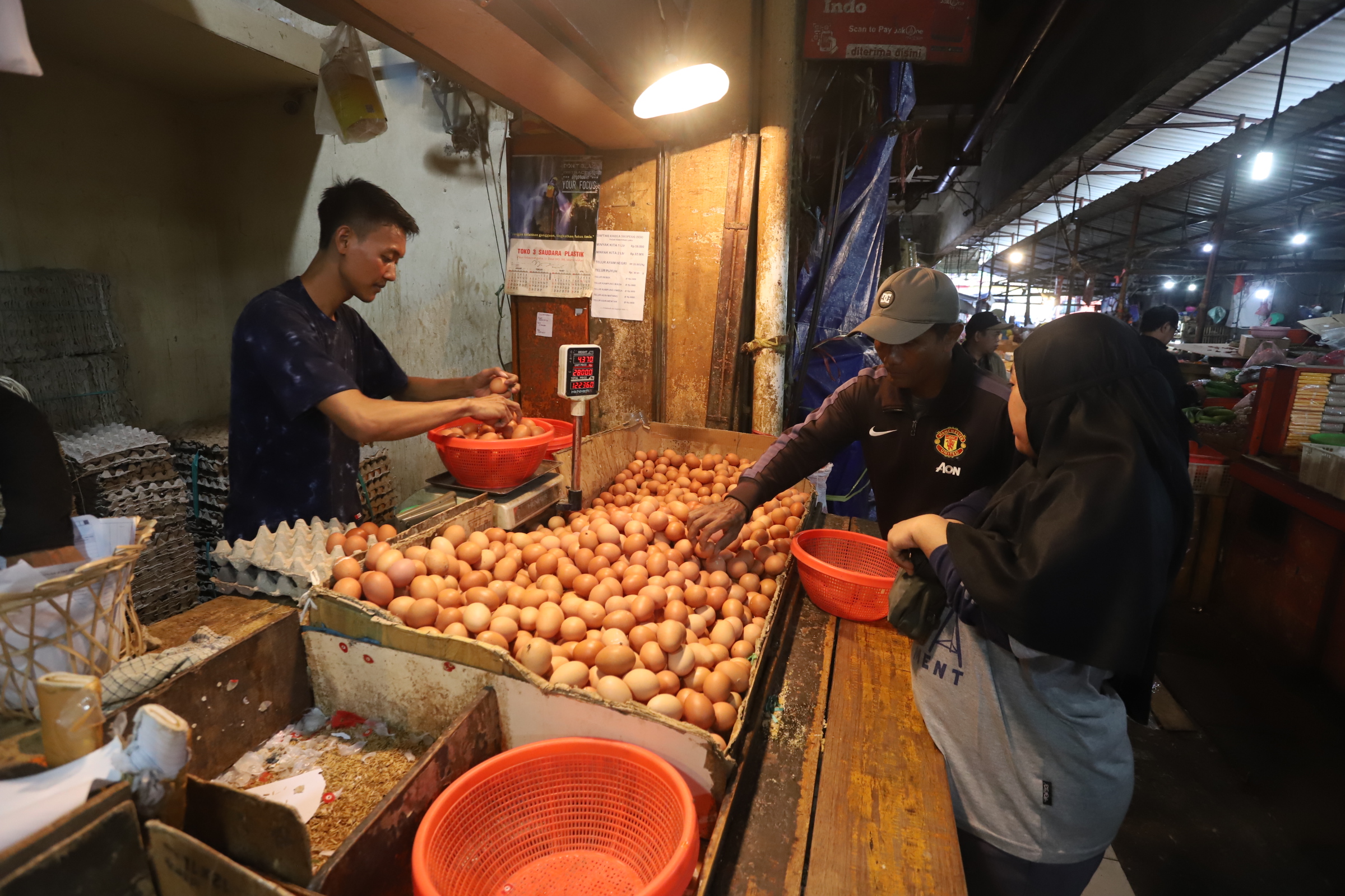 Pedagang saat merapihkan telur ayam di toko miliknya di Pasar Kebayoran Lama, Jakarta,Minggu (5/5/2024).  (BeritaNasional.Com/Oke Atmaja)