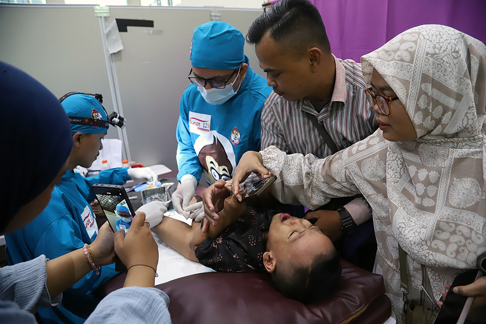 Orang tua dan keluarga menghibur anak peserta Khitanan Massal, di Gedung Juang Merah Putih KPK. (BeritaNasional/Elvis Sendouw)