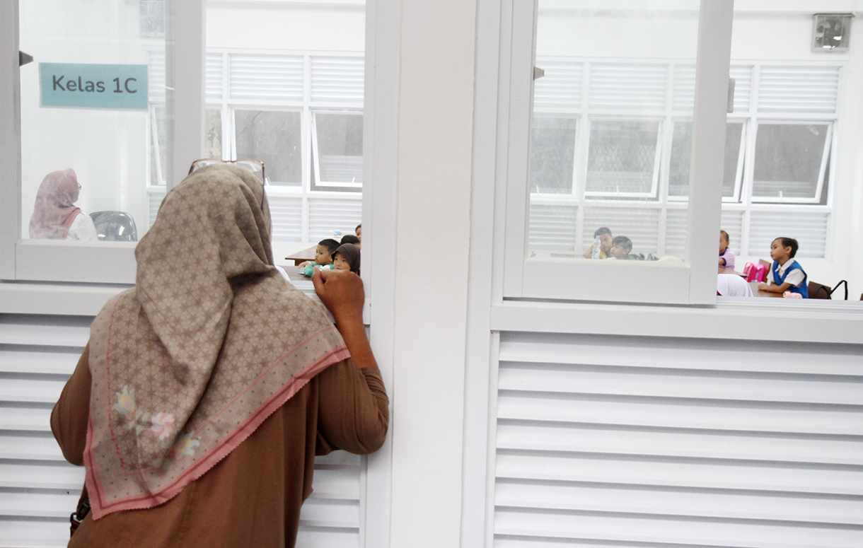 Orang tua melihat anaknya belajar dari lua kelas saat hari pertama masuk sekolah di SDN Cikini 01/02, Jakarta, Senin (14/7/2025). (Beritanasional.com/Oke Atmaja)