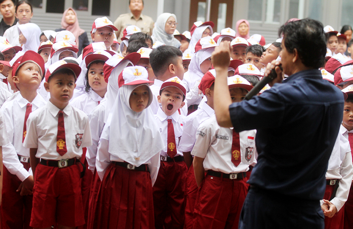 Seorang siswa sekolah dasar menguap saat hari pertama masuk sekolah di SDN 01/02 Cikini, Jakarta, Senin (14/7/2025).  (Beritanasional.com/Oke Atmaja)