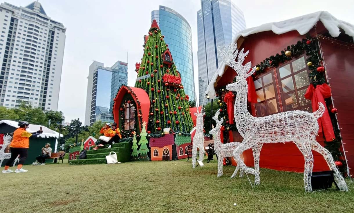 Warga berfoto di dekat dekorasi pohon Natal di West lobby, One Satrio, Jakarta, Sabtu (6/12/2025).  (Beritanasional.com/Oke Atmaja)