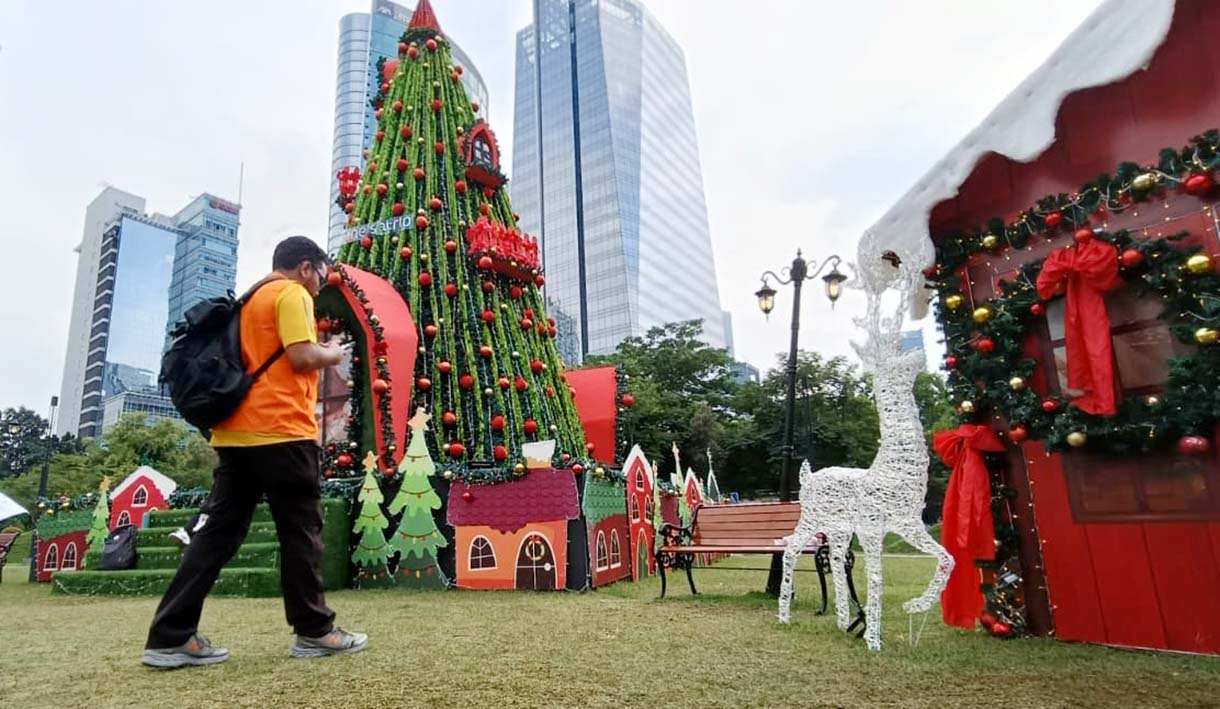 Warga berfoto di dekat dekorasi pohon Natal di West lobby, One Satrio, Jakarta, Sabtu (6/12/2025).  (Beritanasional.com/Oke Atmaja)