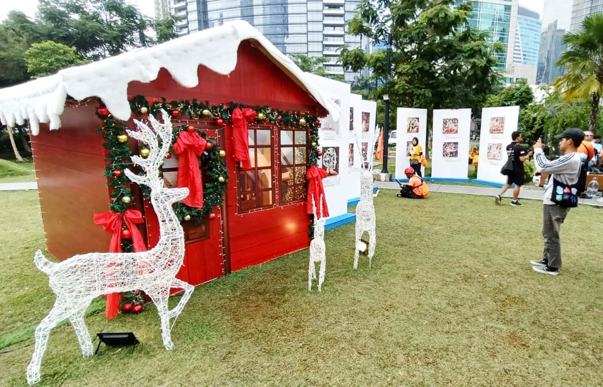 Warga berfoto di dekat dekorasi pohon Natal di West lobby, One Satrio, Jakarta, Sabtu (6/12/2025).  (Beritanasional.com/Oke Atmaja)