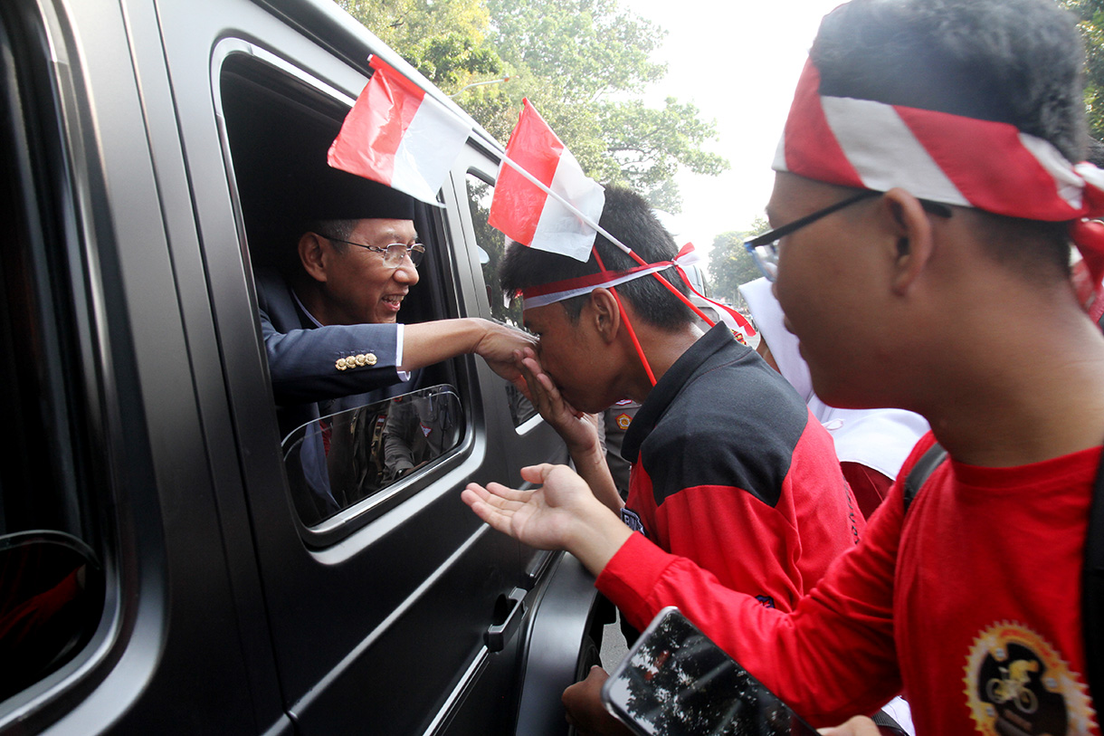 Pj Gubernur DKI Jakarta Heru Budi Hartono menyalami warga Jakarta saat ikut kirab bendera dan teks proklamasi di Kawasan Monumen Nasional, Jakarta, Sabtu (10/8/2024). (BeritaNasional.com/Oke Atmaja)