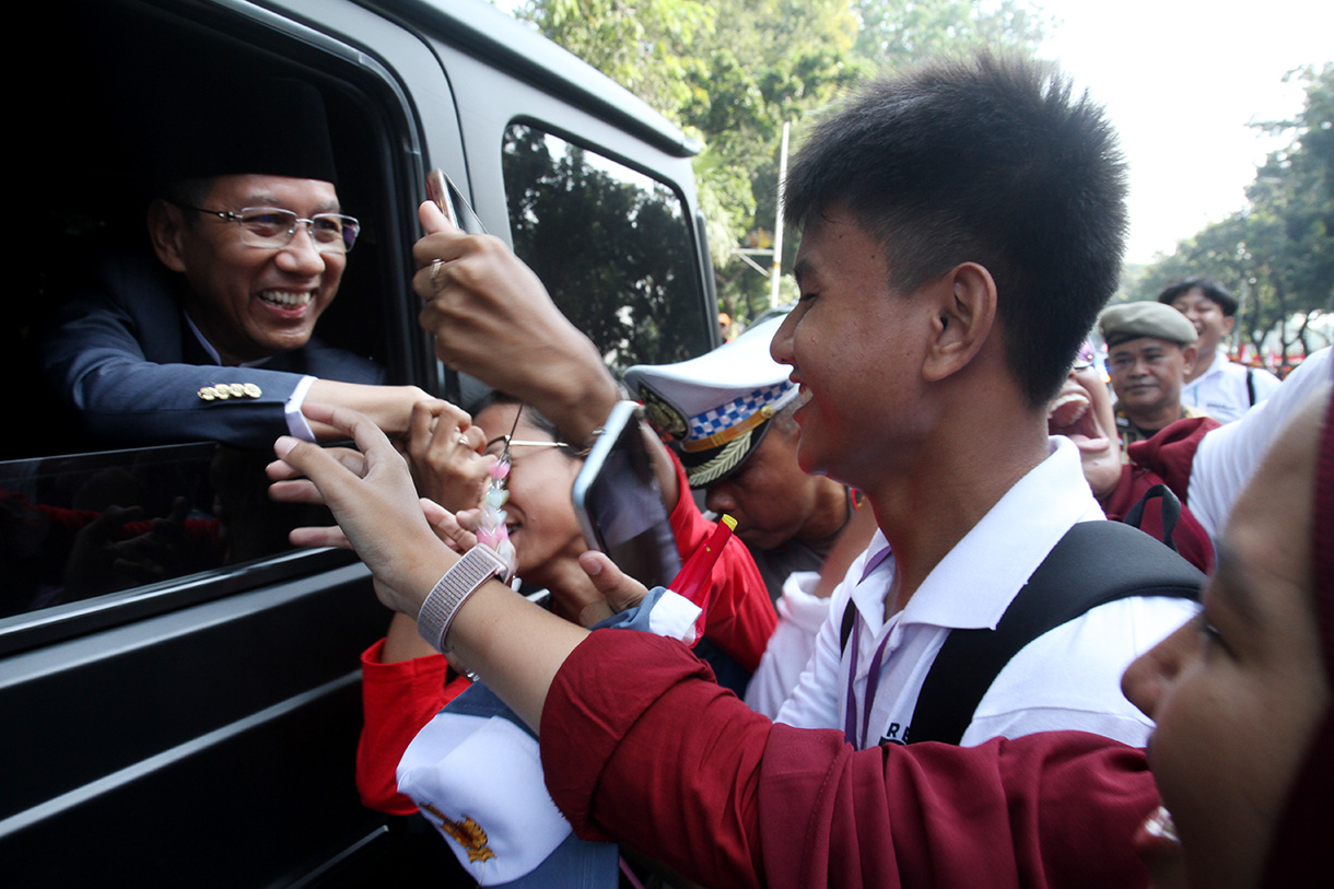 Pj Gubernur DKI Jakarta Heru Budi Hartono menyalami warga Jakarta saat ikut kirab bendera dan teks proklamasi di Kawasan Monumen Nasional, Jakarta, Sabtu (10/8/2024). (BeritaNasional.com/Oke Atmaja)