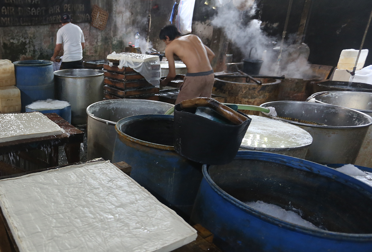 Pekerja menata tahu di salah satu sentra produsen tahu di Kawasan Mampang, Jakarta, Sabtu (11/4/2026).  (Beritanasional.com/Oke Atmaja)