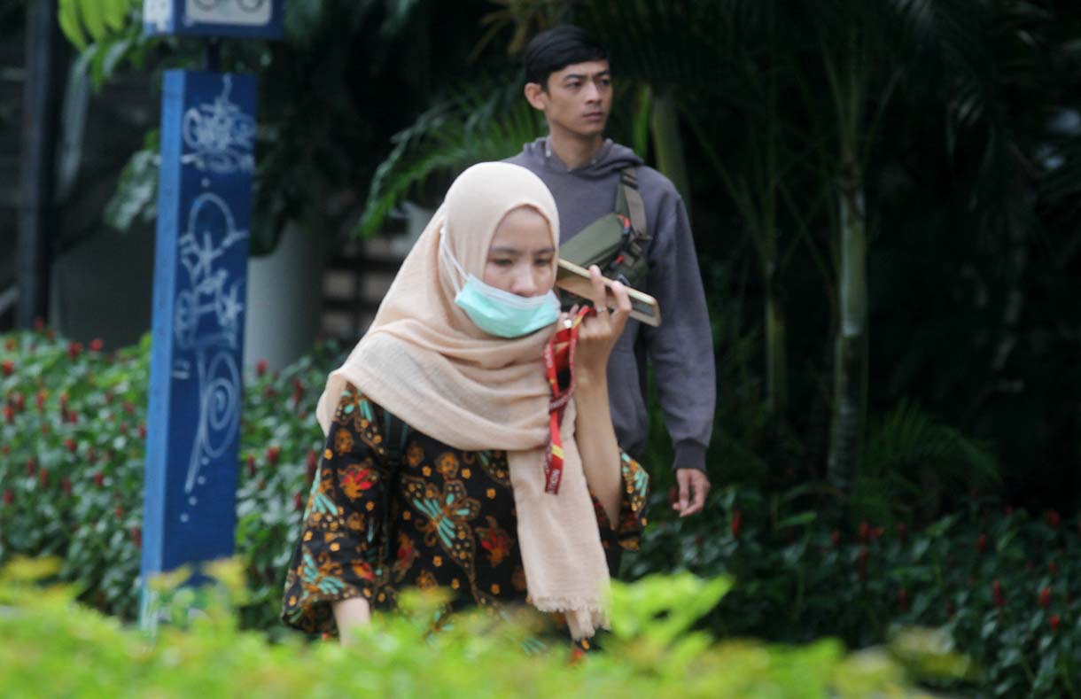 Pekerja melintas di jalan Jenderal Sudirman, Jakarta, Kamis (15/5/2025).  (Beritanasional.com/oke Atmaja)
