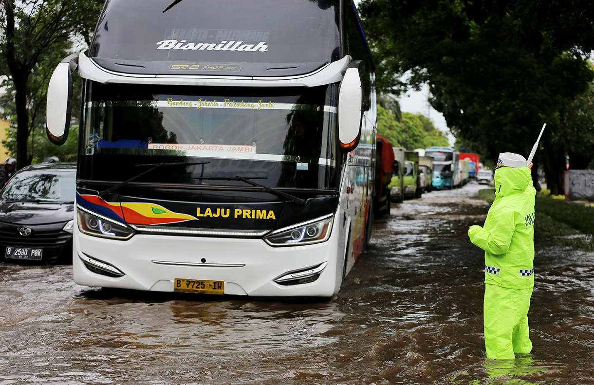 Kendaraan saat melintasi banjir setinggi 30 sampai 50 Cm yang menggenangi Kawasan Jalan Daan Mogot, Kawasan Rawa Buaya, Cengkareng, Jakarta Barat, Senin (12/1/2026). (Beritanasional.com/Oke Atmaja)