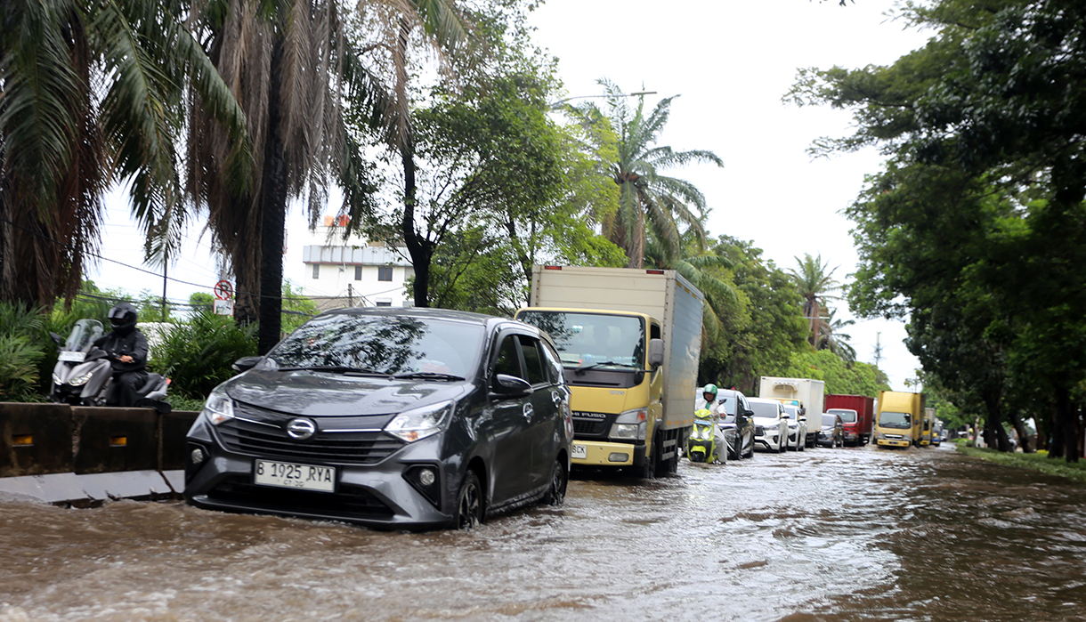 Kendaraan saat melintasi banjir setinggi 30 sampai 50 Cm yang menggenangi Kawasan Jalan Daan Mogot, Kawasan Rawa Buaya, Cengkareng, Jakarta Barat, Senin (12/1/2026). (Beritanasional.com/Oke Atmaja)
