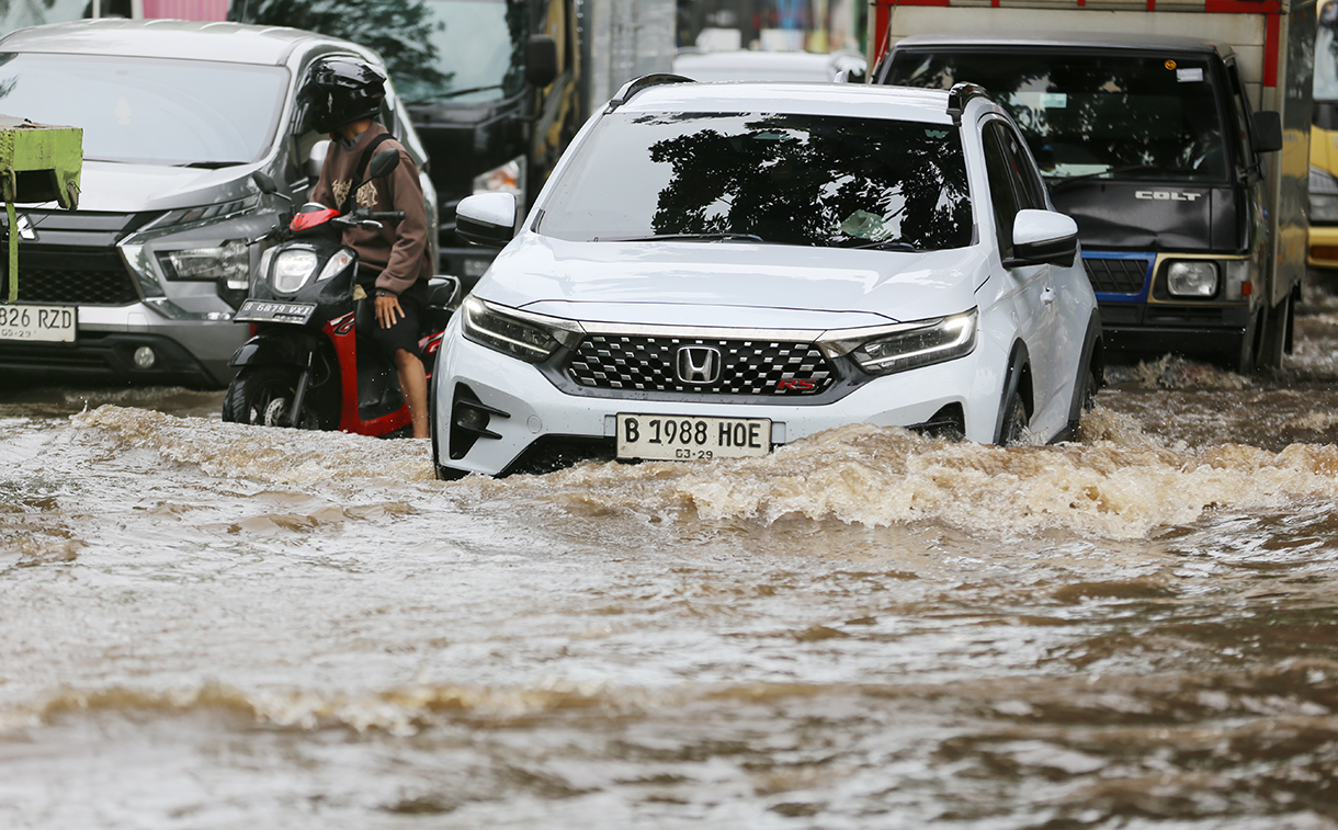 Kendaraan saat melintasi banjir setinggi 30 sampai 50 Cm yang menggenangi Kawasan Jalan Daan Mogot, Kawasan Rawa Buaya, Cengkareng, Jakarta Barat, Senin (12/1/2026). (Beritanasional.com/Oke Atmaja)