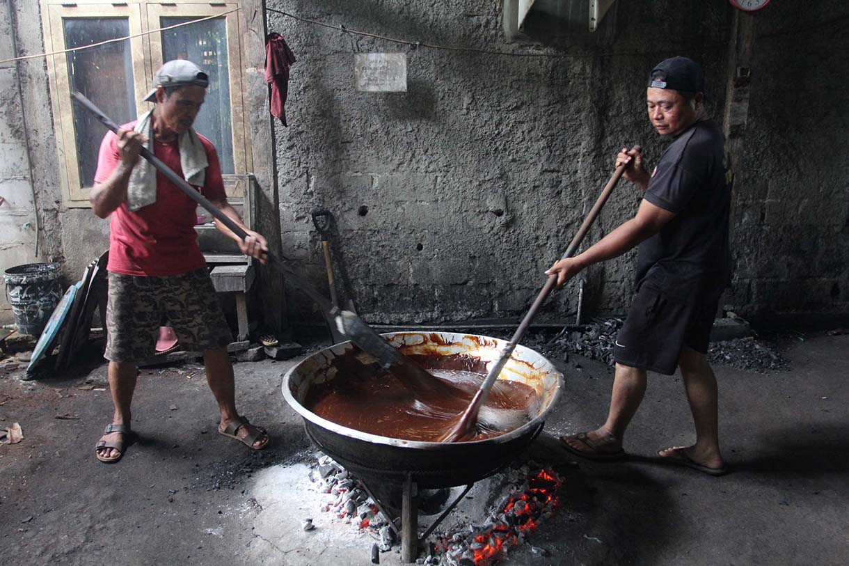 Pekerja mengaduk adonan dodol Betawi di pusat pembuatan dodol, kawasan Cilenggang, Serpong, Tangerang Selatan, Banten, Minggu(16/3/2025).  (Beritanasional.com/Oke Atmaja)