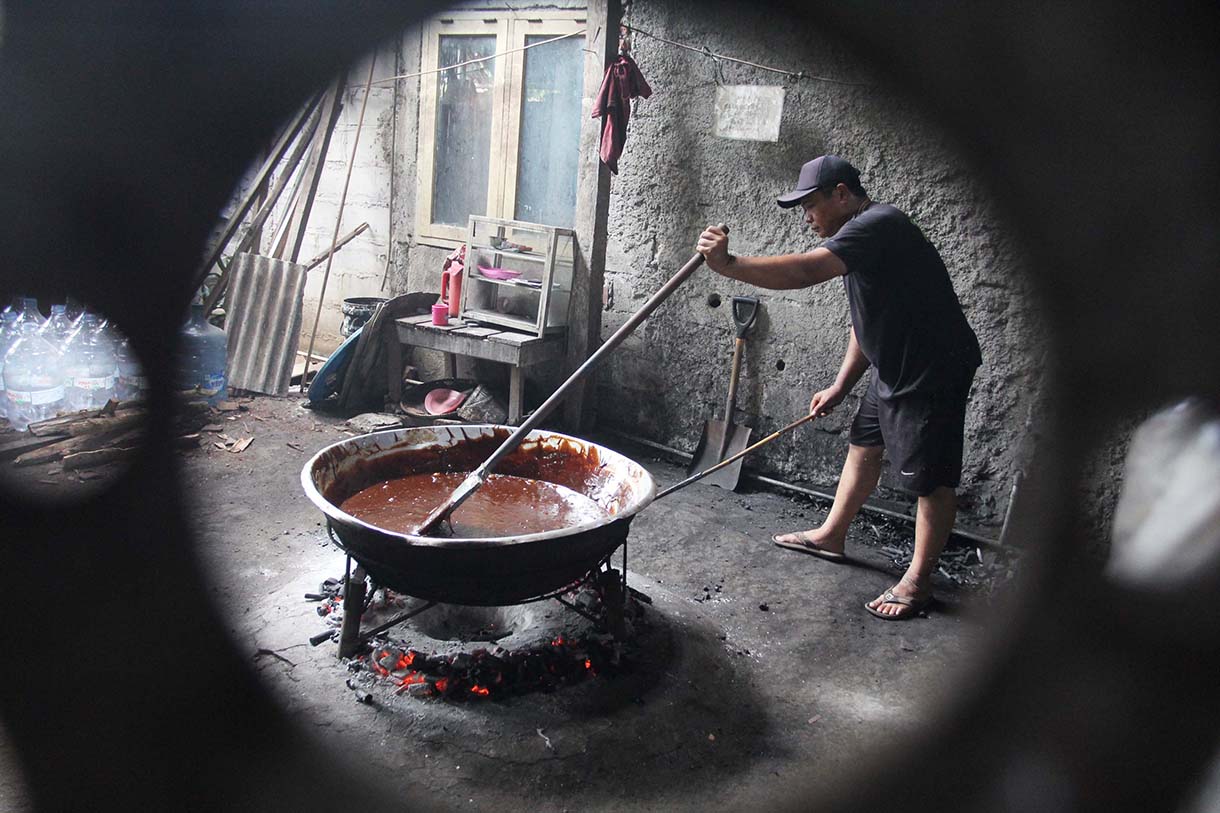 Pekerja mengaduk adonan dodol Betawi di pusat pembuatan dodol, kawasan Cilenggang, Serpong, Tangerang Selatan, Banten, Minggu(16/3/2025).  (Beritanasional.com/Oke Atmaja)