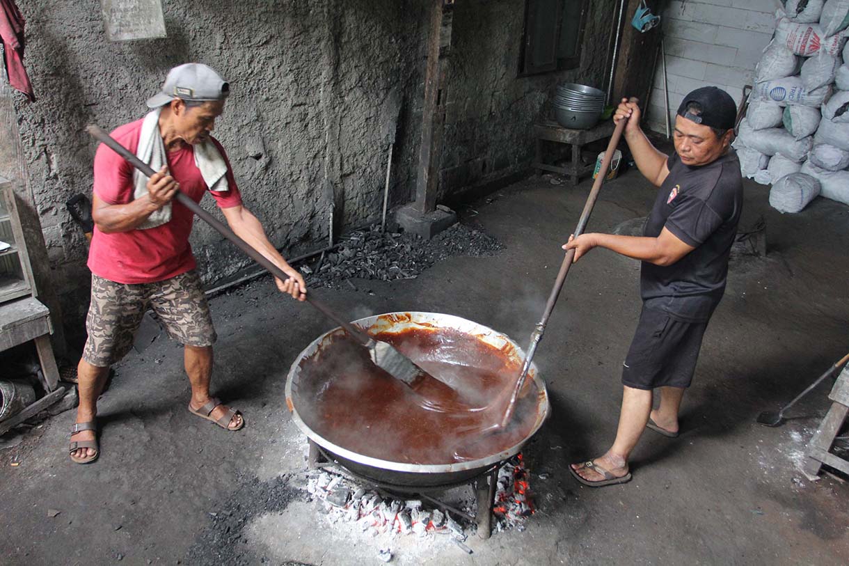 Pekerja mengaduk adonan dodol Betawi di pusat pembuatan dodol, kawasan Cilenggang, Serpong, Tangerang Selatan, Banten, Minggu(16/3/2025).  (Beritanasional.com/Oke Atmaja)