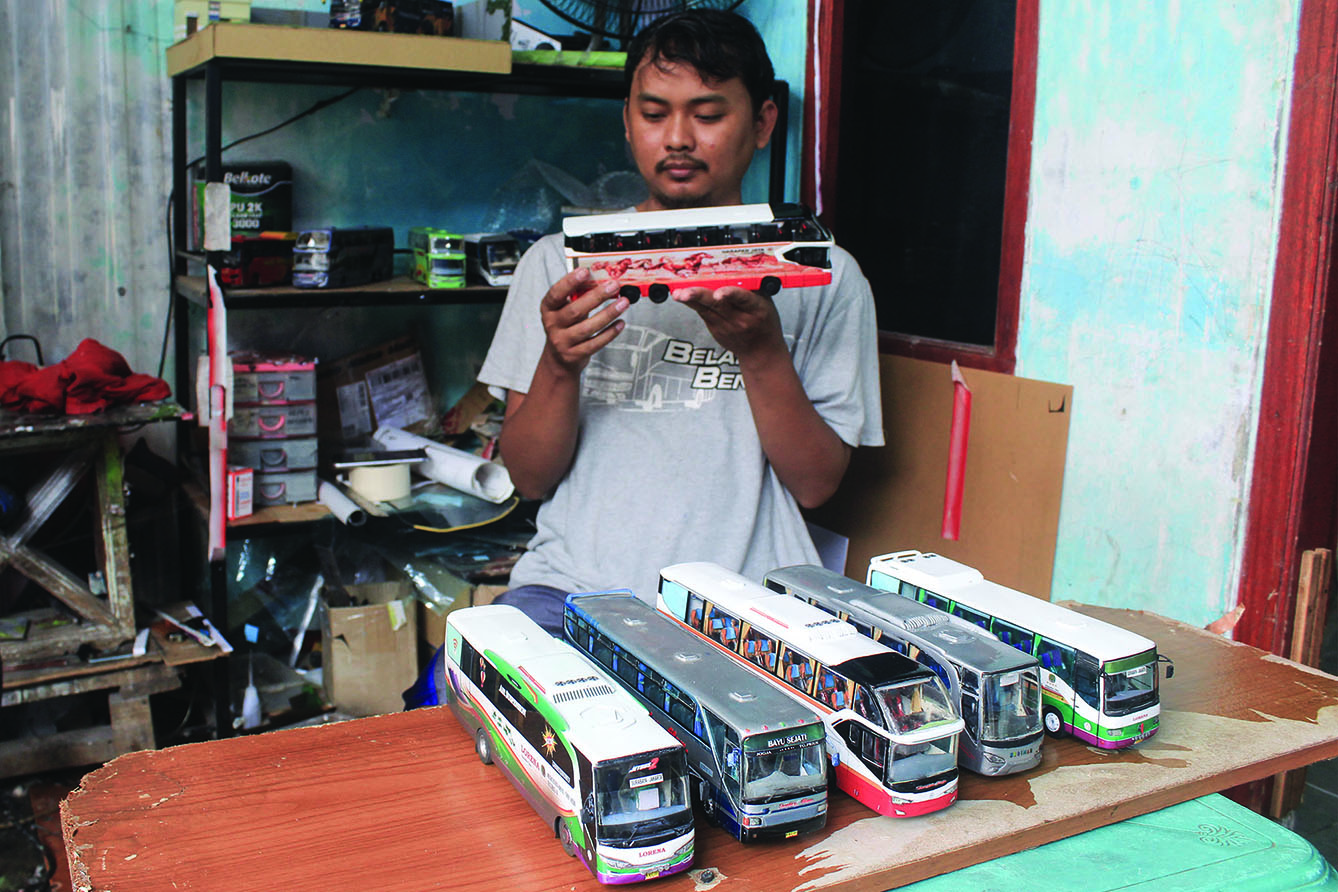 Perajin menyelesaikan miniatur Bus AKAP di Workshop belang bentong, Depok, Jawa Barat, Sabtu (13/7/2024). (BeritaNasional.com/Oke Atmaja)