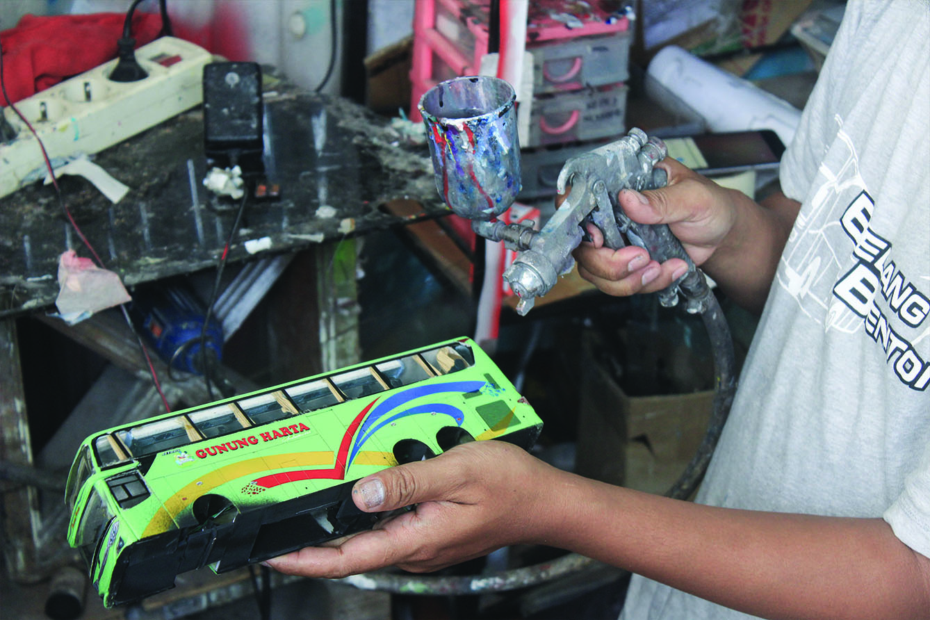 Perajin menyelesaikan miniatur Bus AKAP di Workshop belang bentong, Depok, Jawa Barat, Sabtu (13/7/2024). (BeritaNasional.com/Oke Atmaja)