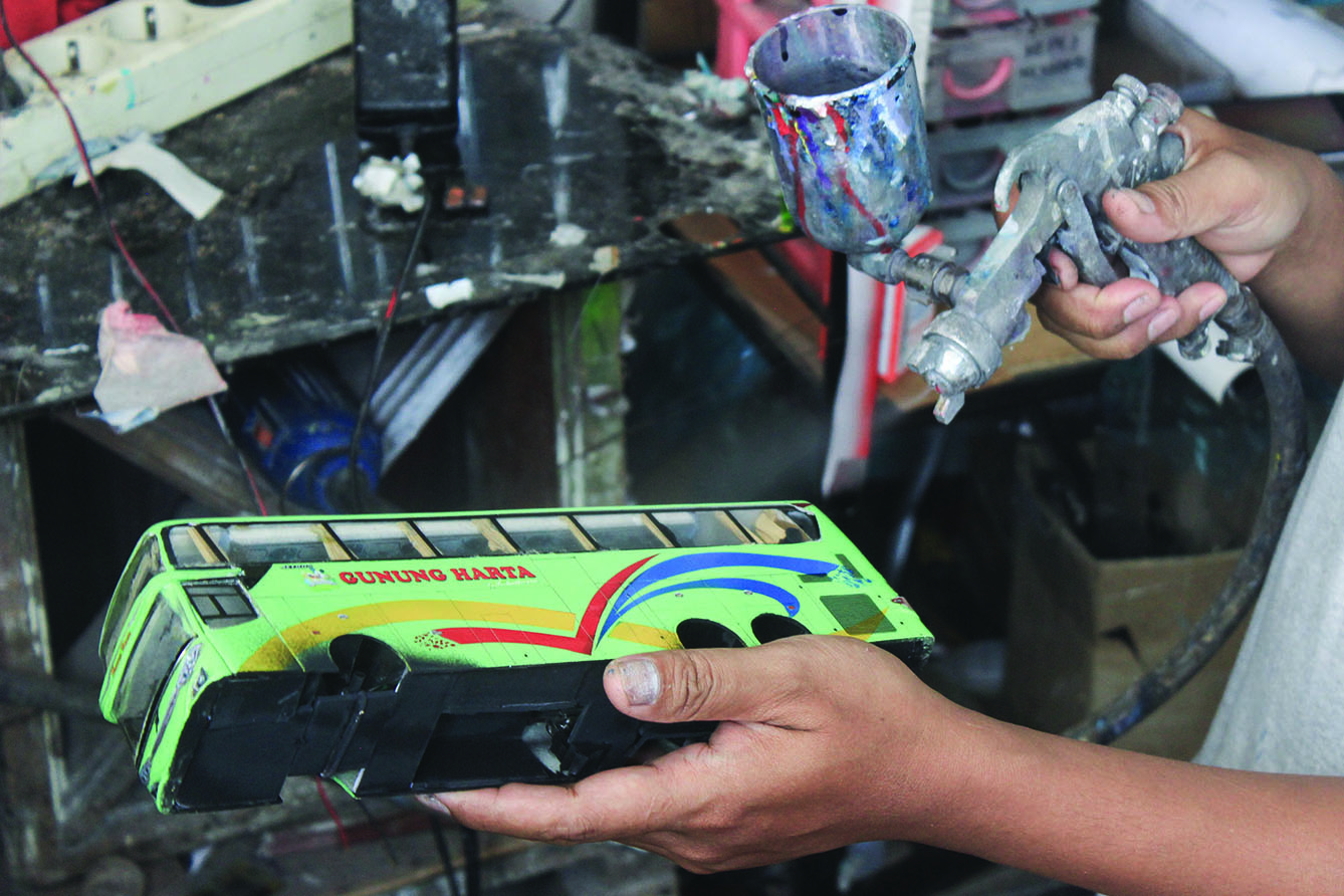 Perajin menyelesaikan miniatur Bus AKAP di Workshop belang bentong, Depok, Jawa Barat, Sabtu (13/7/2024). (BeritaNasional.com/Oke Atmaja)