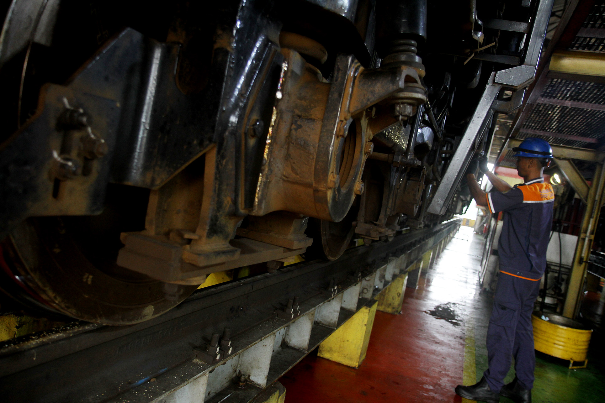 Petugas memeriksa lokomotif kereta api saat perawatan rutin di Depo Lokomotif Cipinang, Jakarta, Selasa (2/4/2024). (Indonesiaglobe/Oke Atmaja)