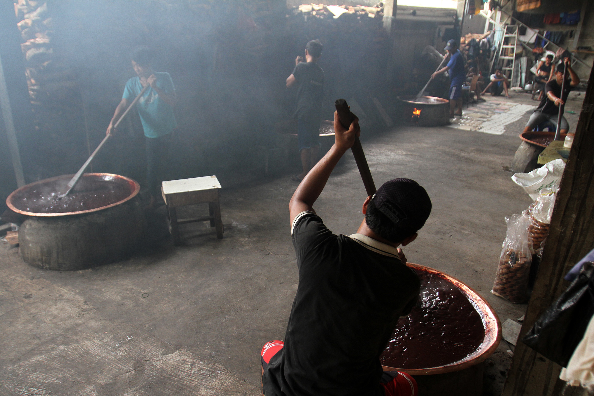 Pekerja memasak dodol Betawi dengan tungku kayu bakar di Sentra Dodol Betawi Wan Salmah di Kawasan Pejaten Timur, Pasar Minggu, Jakarta Selatan, Sabtu (16/3). (Sinarharapan.com/Oke Atmaja)